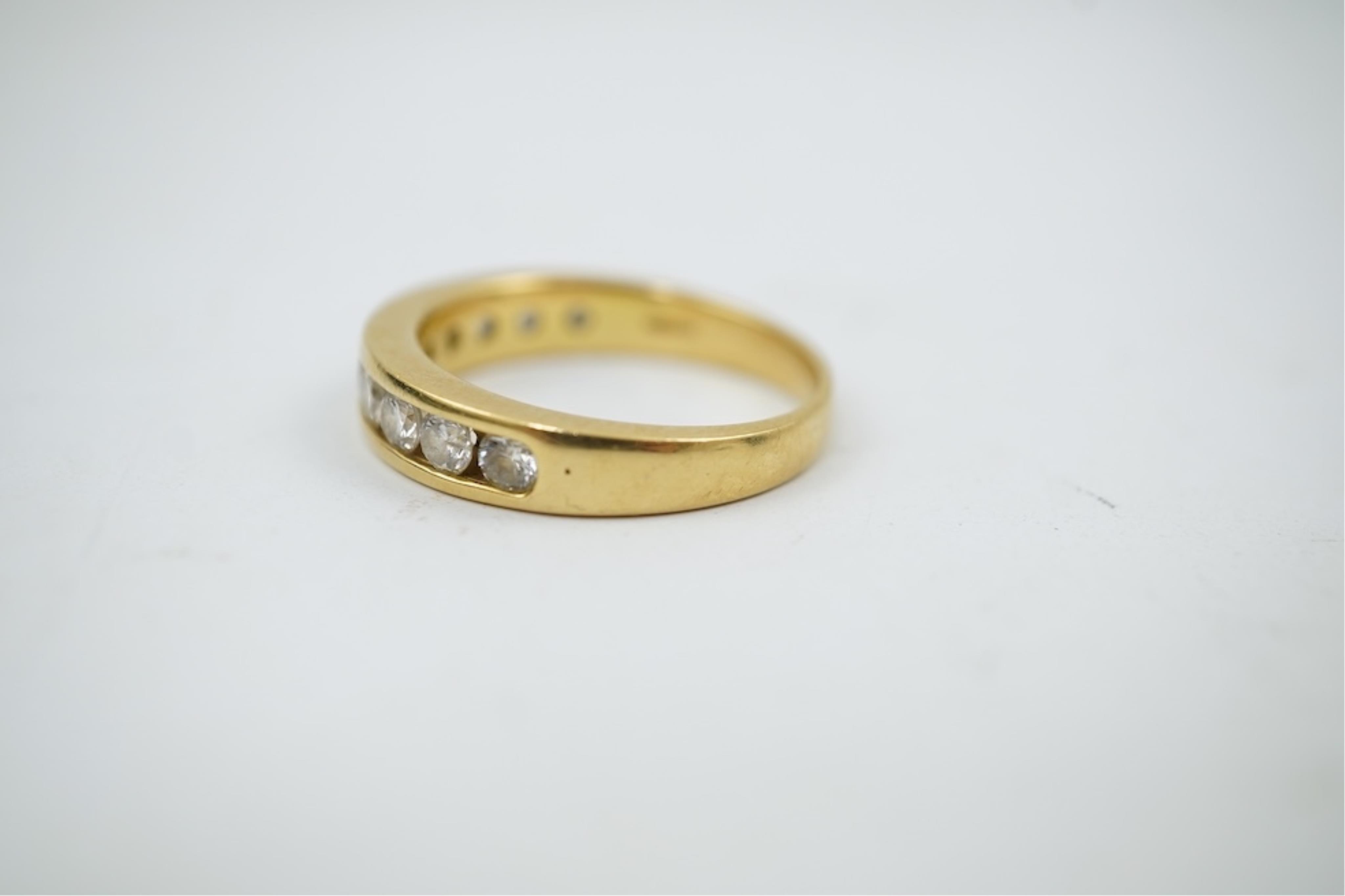 A modern 18ct gold and channel set graduated ten stone diamond set half eternity ring, size Q, gross weight 5.4 grams.